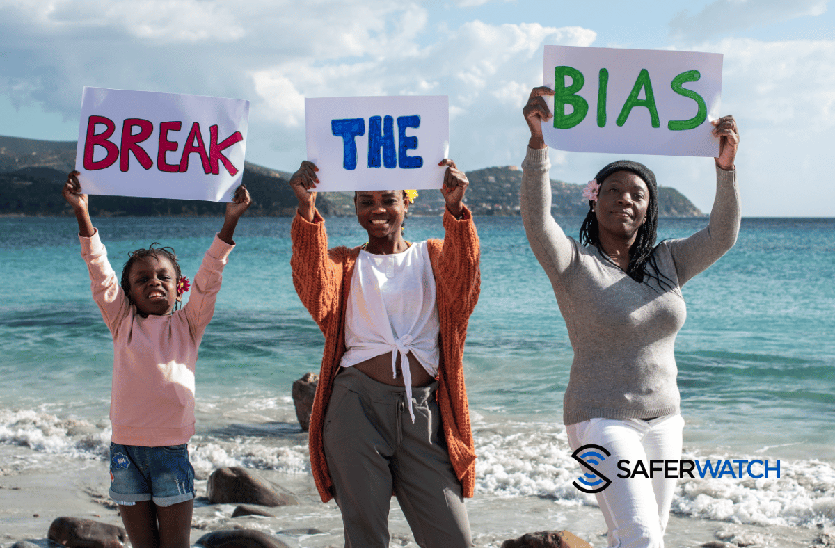 family holding signs that say break the bias on the beach - SaferWatch